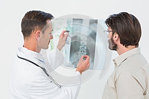 Male doctor explaining spine xray to patient