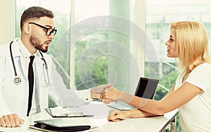 Male Doctor and Female Patient in Hospital Office