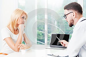 Male Doctor and Female Patient in Hospital Office