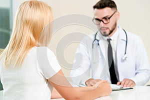 Male Doctor and Female Patient in Hospital Office