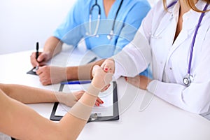 Male doctor and female patient shaking hands. Partnership, trust and medical ethics concept