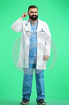 Male doctor, full-length, on a green background