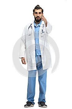 The male doctor, full-length, on a white background, points forward