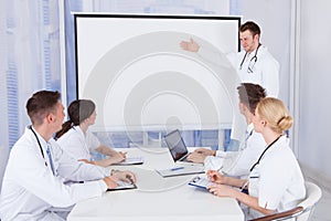 Male doctor giving presentation to colleagues in hospital