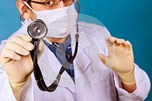 Male doctor hand holding stethoscope for checkup man in medical mask