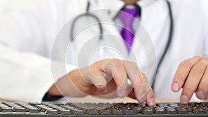 Male doctor hands typing prescription on computer keyboard