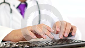 Male doctor hands typing prescription on computer keyboard