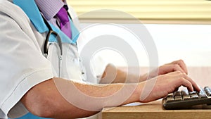 Male doctor hands typing prescription on computer keyboard