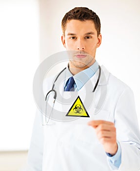 Male doctor holding boihazard caution sign