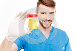 Male doctor holding bottle of urine sample photo