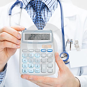 Male doctor holding calculator in hands - health care concept