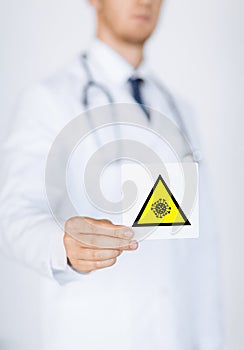 Male doctor holding coronavirus caution sign