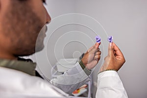 Male doctor holding hearing aid in hands