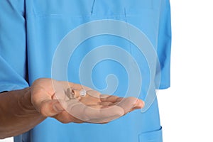 Male doctor holding hearing aid on white background, closeup.