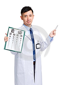 Male doctor holding optometry chart and pen pointing up