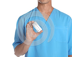 Male doctor holding pills on white background. Medical object