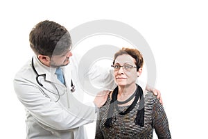 Male doctor holding shoulders to female senior patient