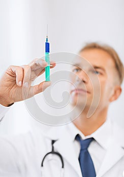 Male doctor holding syringe with injection