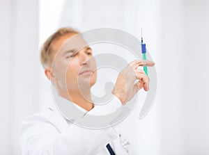 Male doctor holding syringe with injection