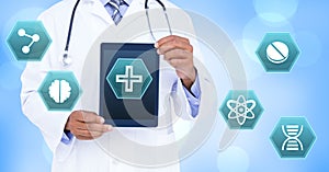 Male doctor holding tablet with medical interface hexagon icons