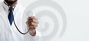 Male doctor listening with stethoscope over light background