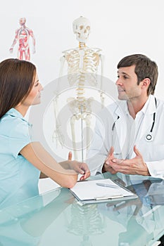 Male doctor listening to patient with concentration at desk