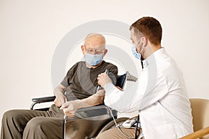 Male doctor and old man on a wheelchair isolated on a white background