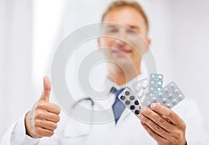 Male doctor with packs of pills