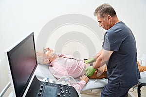 Male doctor palpates the patients abdomen