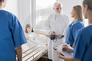 Male doctor with patient and female intern at the hospital