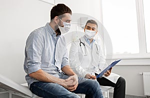 Male doctor and patient in masks at hospital