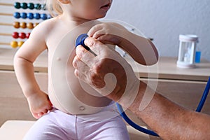 Male doctor pediatrician uses a stethoscope gadget to examine the health of a little patient, baby, little child helps, the