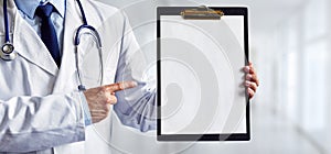 Male doctor pointing to a blank medical clipboard