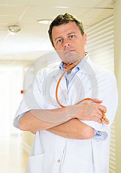 Male doctor portrait victim of Coronavirus disease COVID-19 standing in the hallway of a hospital