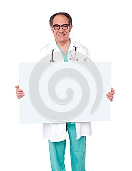 Male doctor posing with white blank billboard