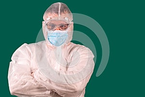 Male doctor in PPE suit uniform standing with arms crossed