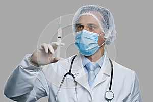 Male doctor preparing syringe for injection.