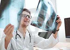 Male doctor radiologist examines x-rays in a medical office.