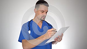 Male doctor reading and writing in medical document