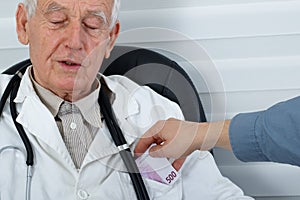Male Doctor receiving money from patient photo