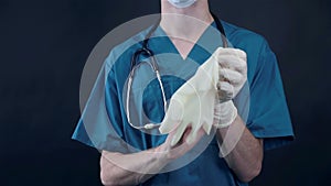 Male doctor removes gloves after hard work.