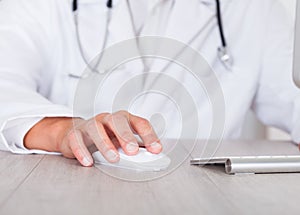 Male doctor's hand using computer