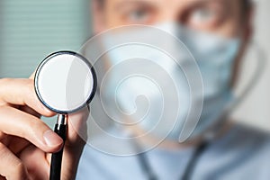 Male doctor showing stethoscope for checkup. Close up of doctor hand holding stethoscope to auscultate breath photo