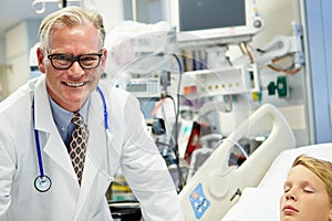 Male Doctor With Sleeping Patient In Emergency Room