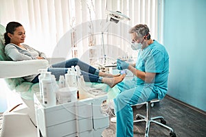 Male doctor with special tool in hands doing medical pedigree procedure in medical center