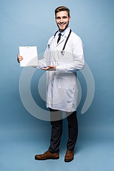 Male Doctor standing with folder, Doc is wearing white uniform and a tie, stands on a light blue background.