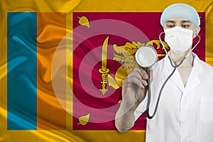 Male doctor with a stethoscope against the background of the silk national flag of sri lanka, concept of national medical care,