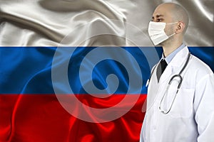 Male doctor with a stethoscope on the background of the silk national flag of Russia, concept of national medical care, health,