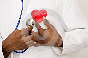 Male doctor with stethoscope holding heart