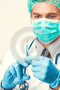 Male doctor with syringe in hands preparing for injection